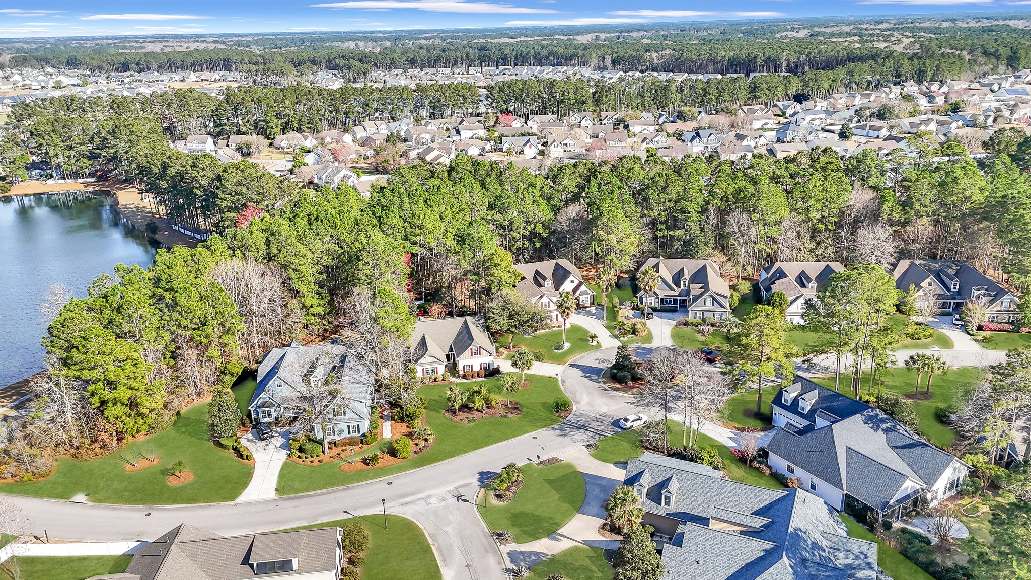 Front exterior of 25 Lakes Crossing in Bluffton, SC with landscaped lawn and two-car garage